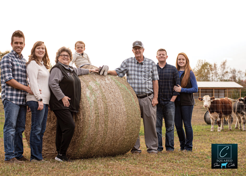 A family stands with a bale of hay. 