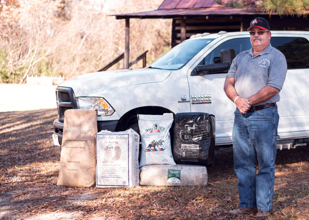 A man stands in front of bedding bags.